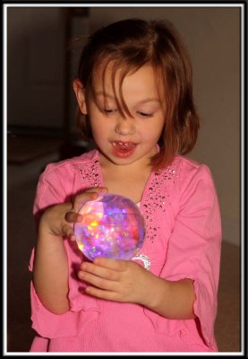 Kylie gives Noelle a light up glowing giant bouncy ball (I call it Saruman's Palantr)