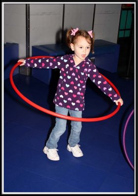 Kylie plays with hula hoops in the cafeteria while waiting for our food