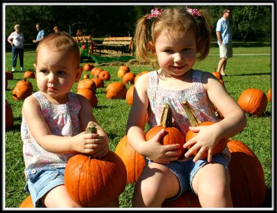 Noelle and Kylie collecting pumpkins