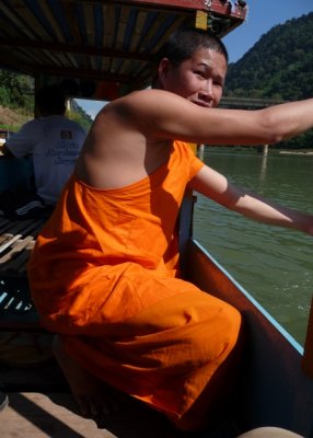 Monk grabs paddle to help boatman manoevre