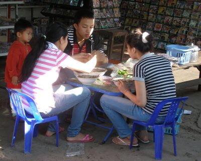 Stallholder family having meal, Talat Sao