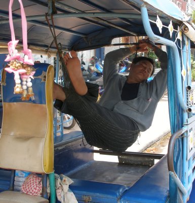 Tuktuk driver dozing between passengers
