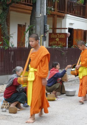 Monks collecting alms outside hotel