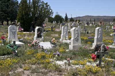 The cemetery is colorful with artificial flowers amongst the tiny wildflowers that survive despite the arid soil.