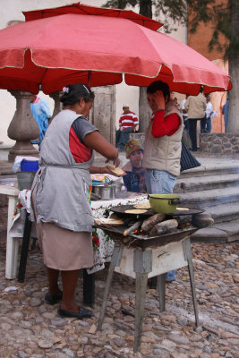 Outside of the church, several people sell religious items as well as fast food.