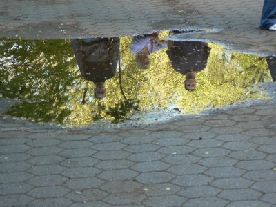 Pedestrians reflecting in puddle