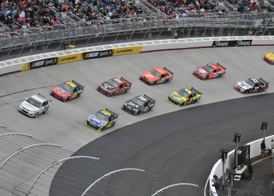 THE PACE CAR LEADS THE RACE CARS AROUND THE TRACK