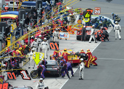 FRANTIC ACTIVITY IN THE PITS, UNDER THE WATCHFUL EYES OF NASCAR OFFICIALS