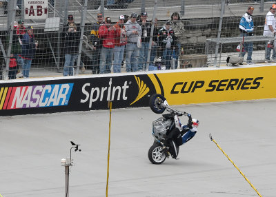 MOTORCYCLE STUNT RIDER,  CHRISTIAN PFEIFFER, DOES A GIANT WHEELIE BEFORE THE RACE