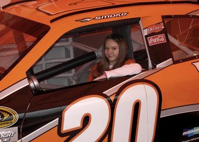 OUR GRANDDAUGHTER SITS IN THE TONY STEWART DISPLAY RACE CAR