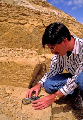 (SG49) Geologist measuring strike with a Brunton Compass