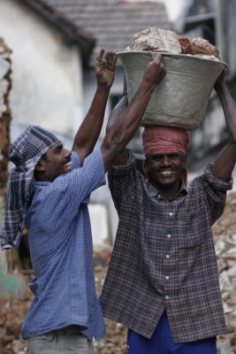 these men were loading a demolished brick building by hand and carrying on their heads