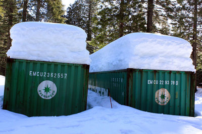 Snowshoe pole between these storage containers helps illustrate snow depth