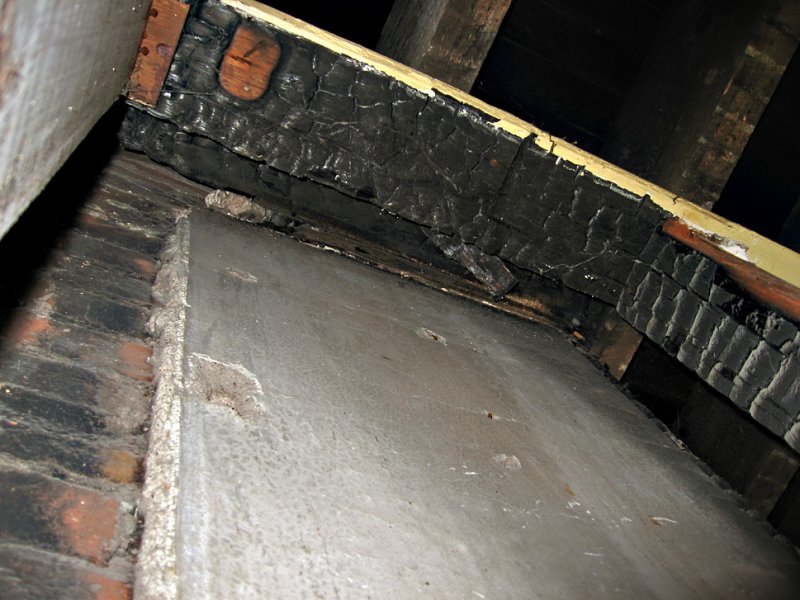 The ceiling beam and joist are burnt above the stove location.<br>7823.