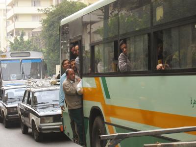 An overfilled bus in the usual heavy traffic.