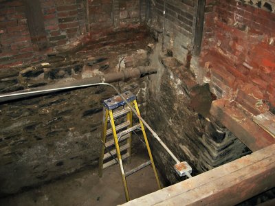 A corner of the basement, with stepladder holding up the electrical conduit7824