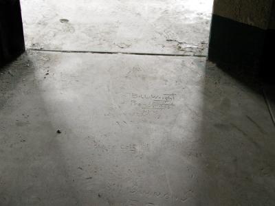 A Block, Cell 48 -- Graffiti carved in floor near door