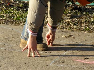 Valeria playing hopscotch in a sunny day