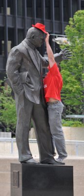 Removing his red hat from statue
