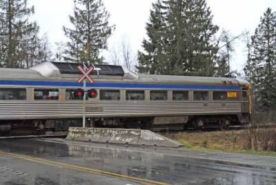 E & N Via Rail Budd car zips past a crossing.