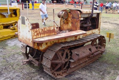An unrestored Caterpillar Fifteen, in as-found condition, with a Cat 2-Ton to the left.