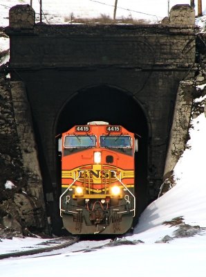 A westbound BNSF train goes toward the light at the west portal of Mullan Tunnel. 04/06/08