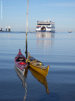 portrait of two kayaks and a ferryboat