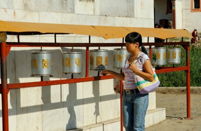 A woman turns prayer wheels at Gandan Monestary