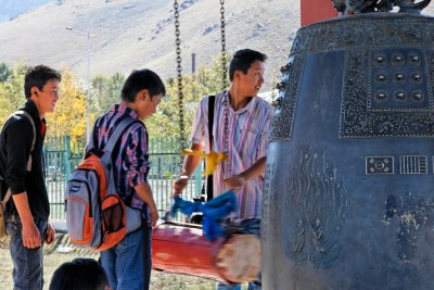 Mongolian teenagers ring a bell in a public park