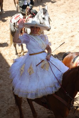 THE FIESTA QUEEN SIDE SADDLE ON A HORSE AT THE CHARREADA
