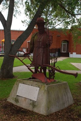 THE SCULPTURE OF A FARMER BETWEEN THE CHURCH AND RECTORY IS NOT TO BE MISSED