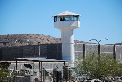 THERE WERE GUARD TOWERS AT EVERY CORNER AND RAZOR WIRE SURROUNDED THE PRISON