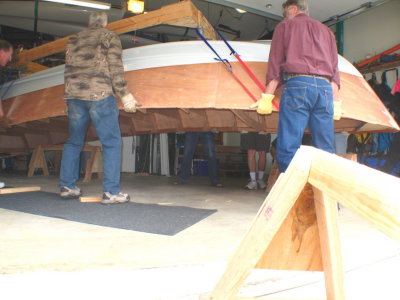 Sawhorses removed as eight helpers lift the hull.  An easy lift with this many guys.