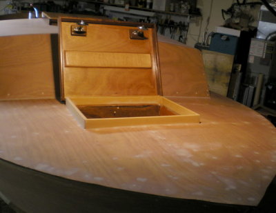 Forward cuddy hatch flips back: a simple box, here open; latches installed on captured bolts.