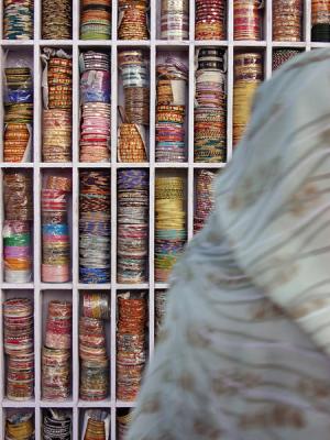 Woman in sari passing a bracelet stand, Pushkar.