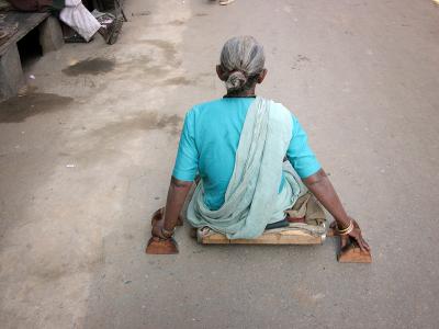 Woman who gets around on a board with wheels, Pushkar.