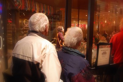Grandmother and grandfather watch their grandson perform on stage