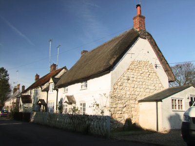 A  row  of  thatched  white  walled  cottages, some  without  thatches.