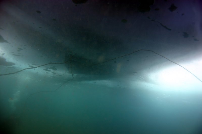Several tether lines running through the hole, tenders managing them at the surface