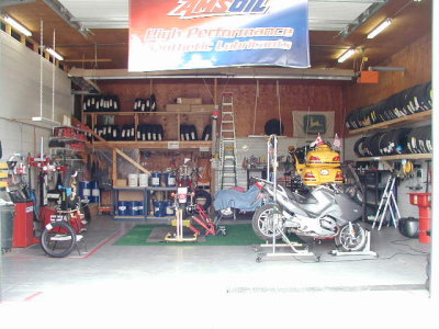 Entrance into the new shop area will be through the wall  where the white steel is infront of the Yellow bike on the lift..JPG