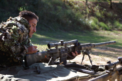 A Special Forces sniper ejects a shell from his SR-25 semi-automatic sniper rifle thats been outfitted with a silencer.