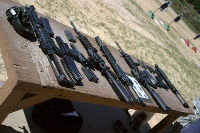The table at the firing range displays two sets of the four weapons we were allowed to play with  from left to right, the MP5, Glock, Beretta, and M4.