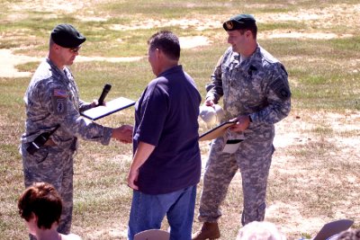My father receives an award for being one of the two most accurate shooters on the target range earlier in the day.