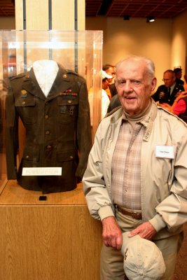 John Breen poses with his wartime dress coat, which is on display with other 101 artifacts at the ASOM special exhibition.
