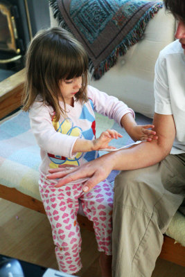Putting a make-believe bandaide on Mummy's arm.