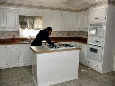 Beth looking in the cabinet under the stove top.