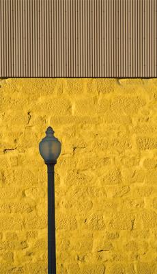 Lone lamp against yellow wall