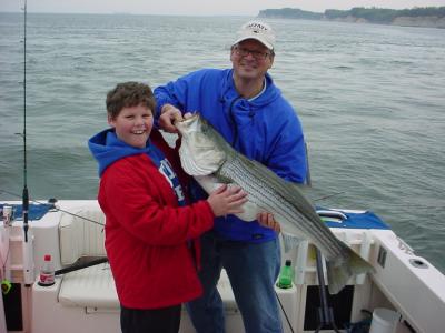 4/14/2006 Alex caught this one at the Rips on light spin tackle.. Dad helps show off  nice 40+ Striper for release