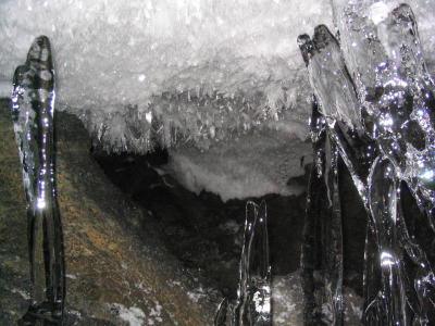 Clear-ice stalagmites, 3' tall, in front of long ceiling crystals.JPG