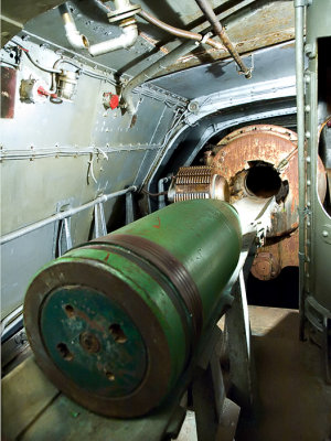Inside a gun turret : Loading 1,400 pound shell into breach of 14 inch gun. Range: 12 miles
